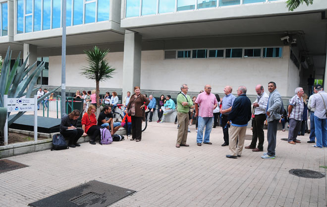 Un grupo de vecinos esperando respuestas a las puertas de la sede de Aguas de Cádz / FOTO: Eulogio García