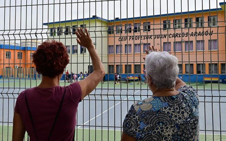 Madre y abuela despidiendo a su niño desde la verja / FOTO: Eulogio García