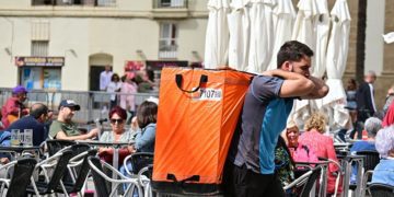 Mensajero de una multinacional sorteando terrazas en Cádiz / FOTO: Eulogio García