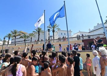 Un grupo de niños animando el acto de izado en La Caleta / FOTO: Eulogio García