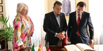 Alcalde y consejero releen lo escrito por Sanz en el Libro de Honor, 'observados' por el Borbón / FOTO: Eulogio García