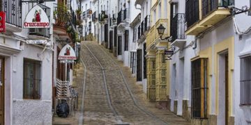 Calle empedrada con casas blancas en Cadiz España