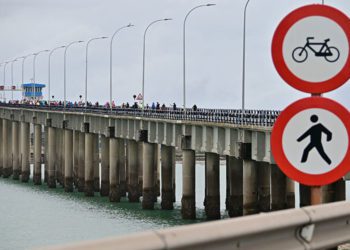 La marcha cruzando el puente, que 'saluda' con las señales que prohíben bicis y peatones / FOTO: Eulogio García