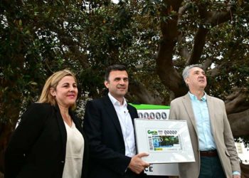 Presentando el cupón bajo el árbol centenario / FOTO: Eulogio García