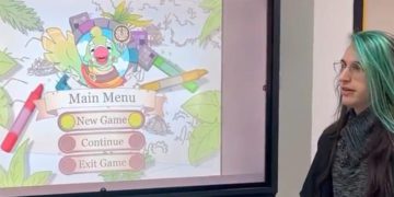 Una de las alumnas desarrolladoras explica el juego a representantes de Ustea / FOTO: Ustea