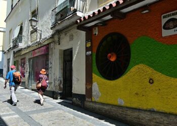 Turistas pasan por la puerta de la finca señalada / FOTO: Eulogio García