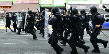 Antidisturbios corriendo detrás de los manifestantes por la avenida / FOTO: Eulogio García