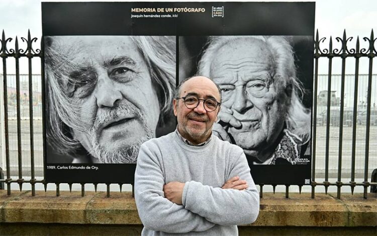 Kiki posando en la verja del muelle con una de sus exposiciones / FOTO: Eulogio García