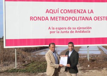 Román y Vera bajo la valla que deja en evidencia a la Junta / FOTO: Ayto.