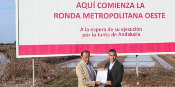 Román y Vera bajo la valla que deja en evidencia a la Junta / FOTO: Ayto.