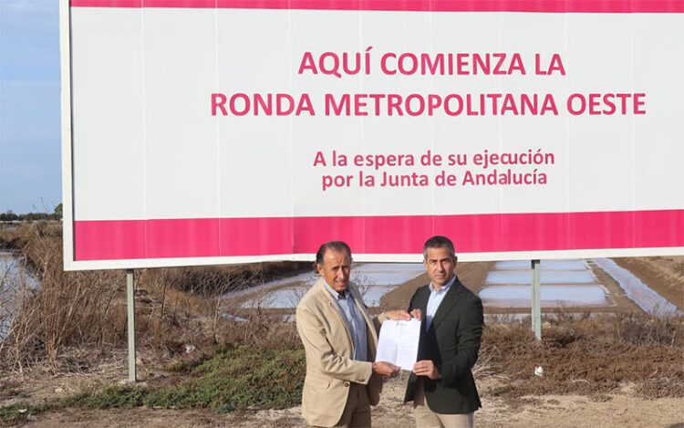 Román y Vera bajo la valla que deja en evidencia a la Junta / FOTO: Ayto.