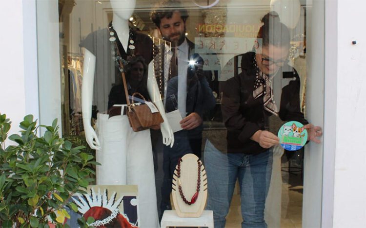 Colocando el distintivo de la campaña en un escaparate / FOTO: Ayto.