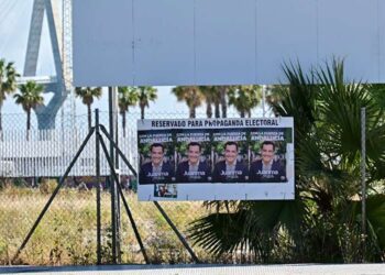 Simbólica propaganda electoral del PP bajo la valla desgastadas del prometido hospital de Cádiz / FOTO: Eulogio García